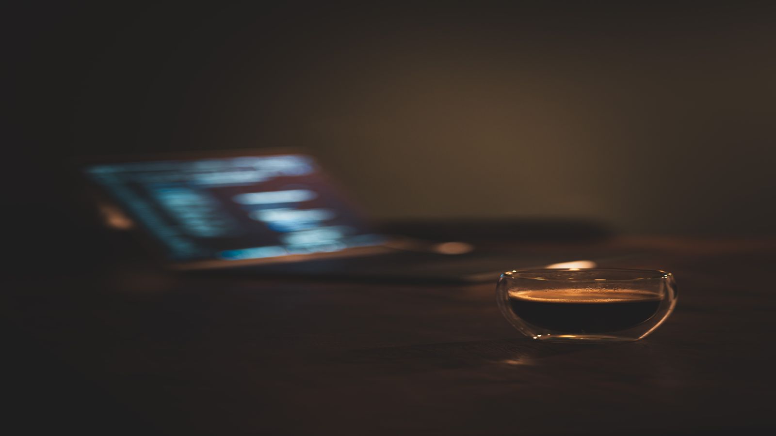 An empty desk with a closed laptop and a coffee mug