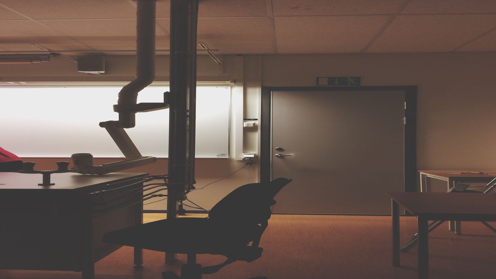 A quiet private office with a closed door and a monitor showing code